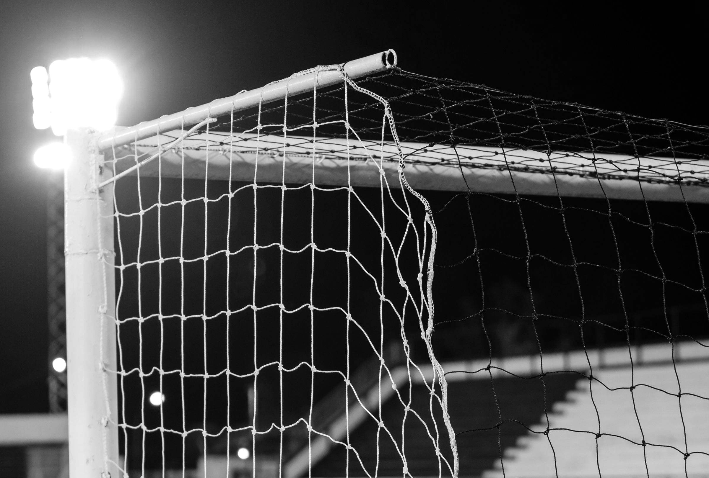 Goalpost and net under a floodlight at night